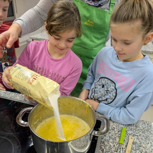 2 Mädchen geben Zucker in die Marmelade
