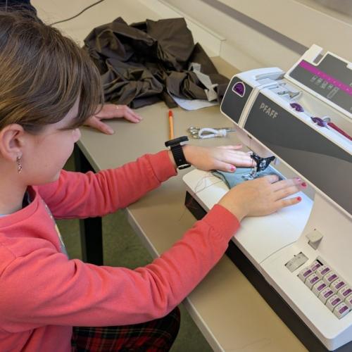 Mädchen an der Nähmaschine