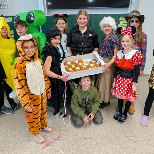 Gruppe von verkleideten Kindern mit Faschingskrapfen