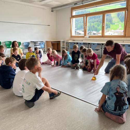 Kinder sitzen um Bee-Bot-Teppich