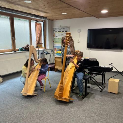 Kinder an der Harfe