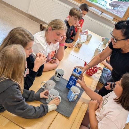 Julie bereitet mit Kindern den Tee zu