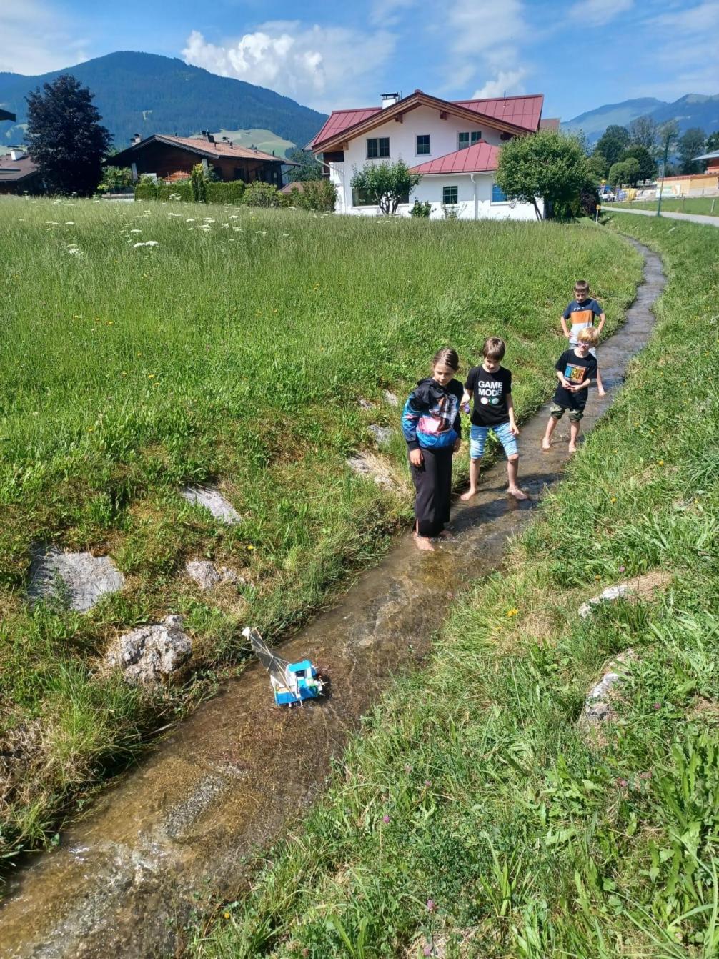 Die Boote werden im Bach von den Kindern aufgefangen. 