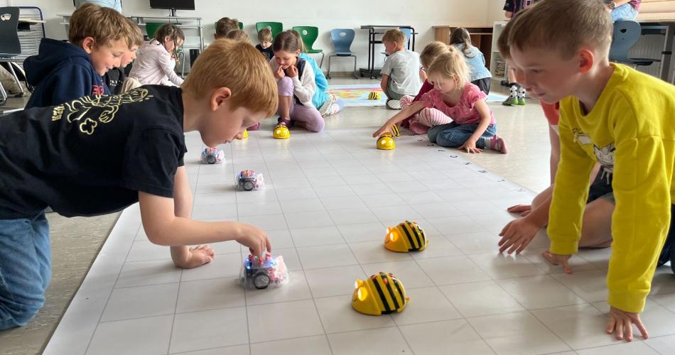 Kinder arbeiten mit Bee-Bots
